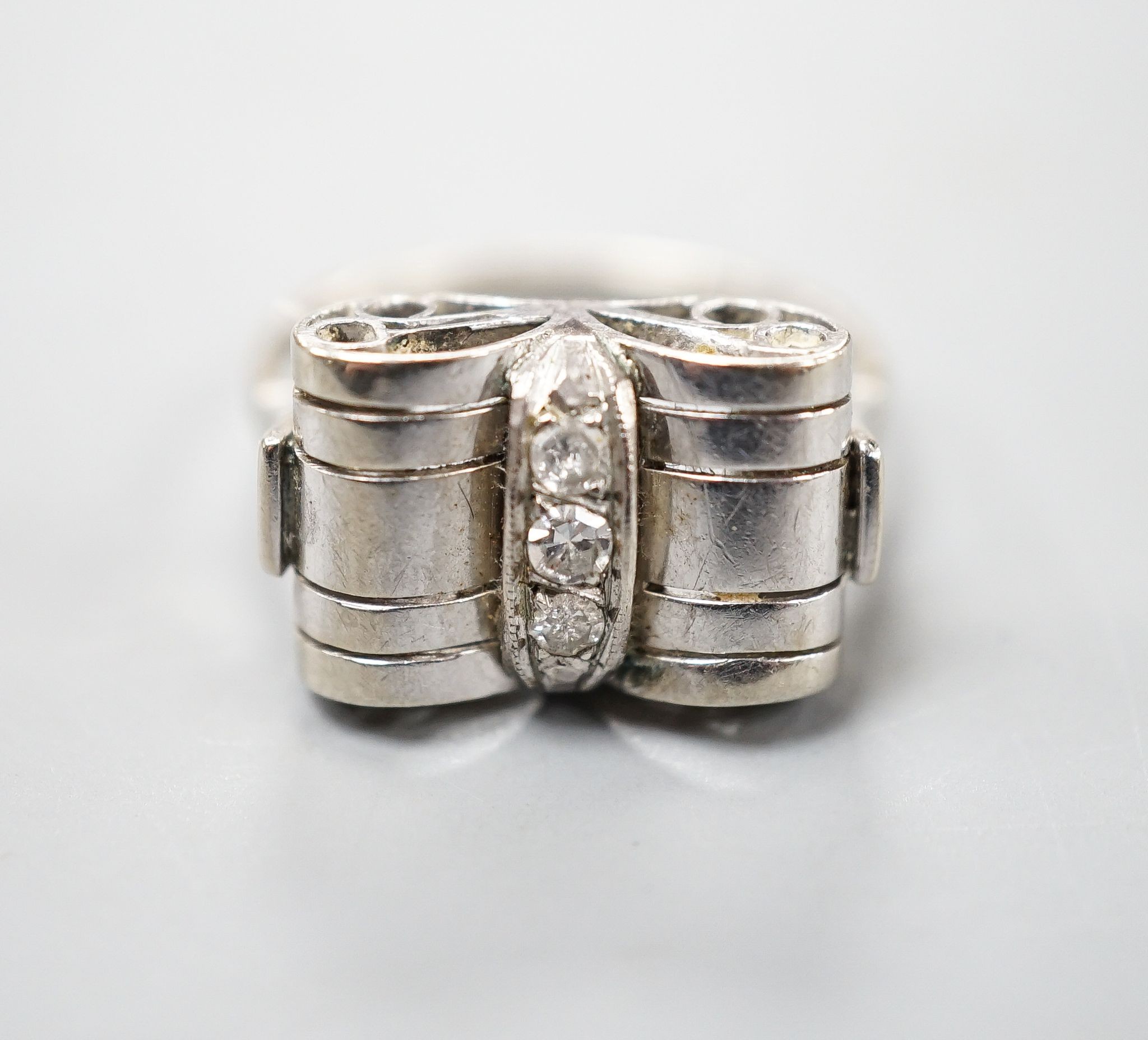 A 1940's white metal and three stone diamond set dress ring, size P, gross weight 3.5 grams.